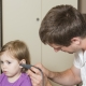 Logopäde untersucht Ohr von kleinem Mädchen